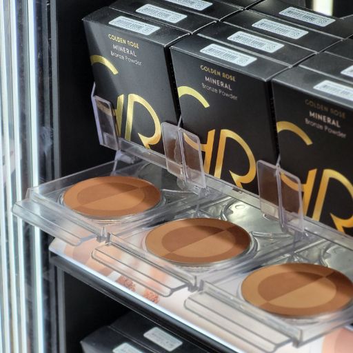 Gedetailleerde weergave van de Golden Rose make-up producten in de Wall Unit Display.